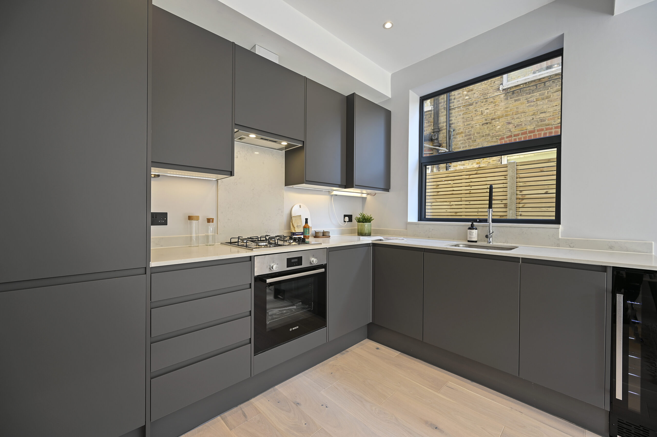 Open-plan reception and kitchen of the refurbished flat at Larden Road, Acton W3
